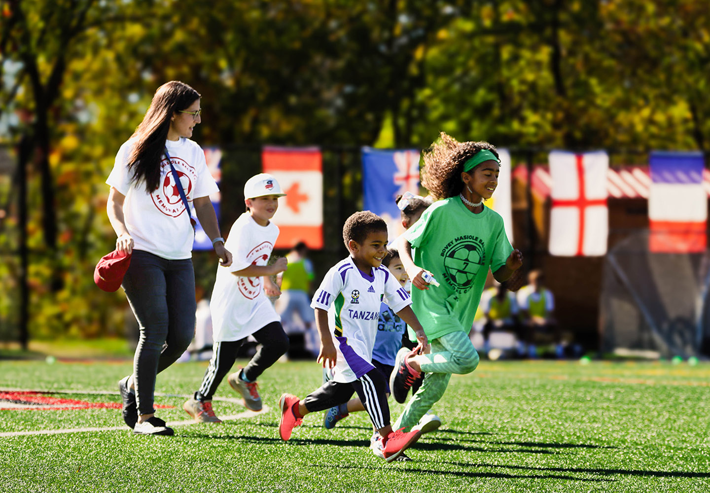 Children run across the soccer field 