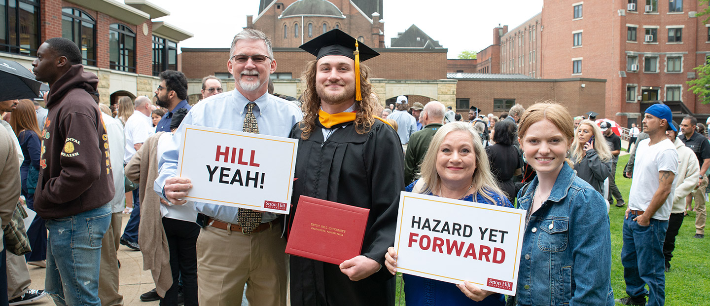 A recent grad stands with his family.