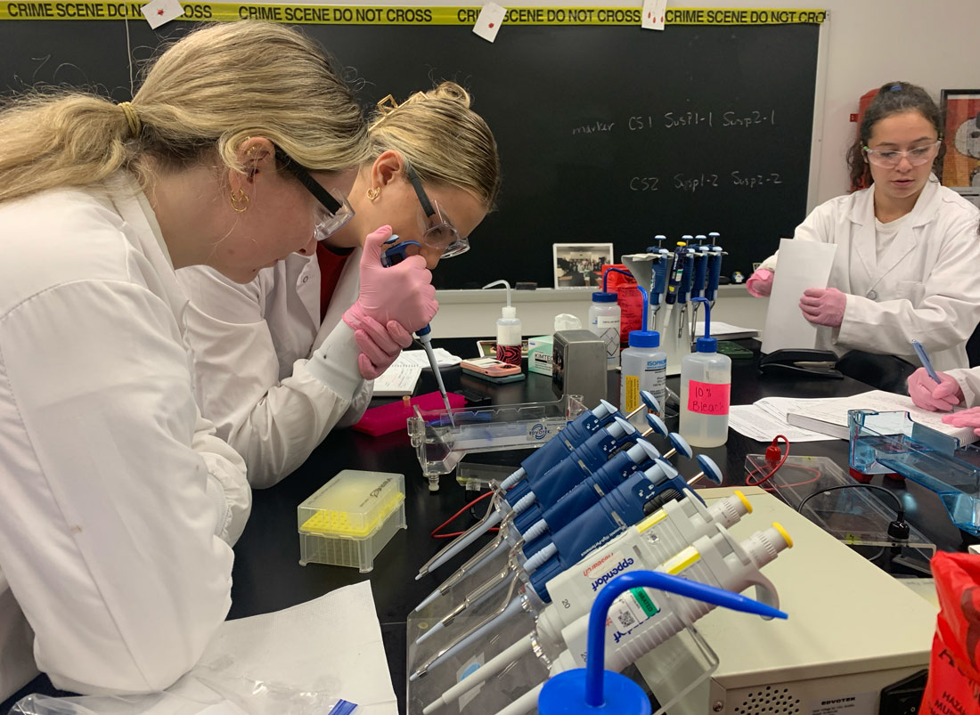 Forensic Science students loading an agarose gel in Forensic Molecular Biology Lab