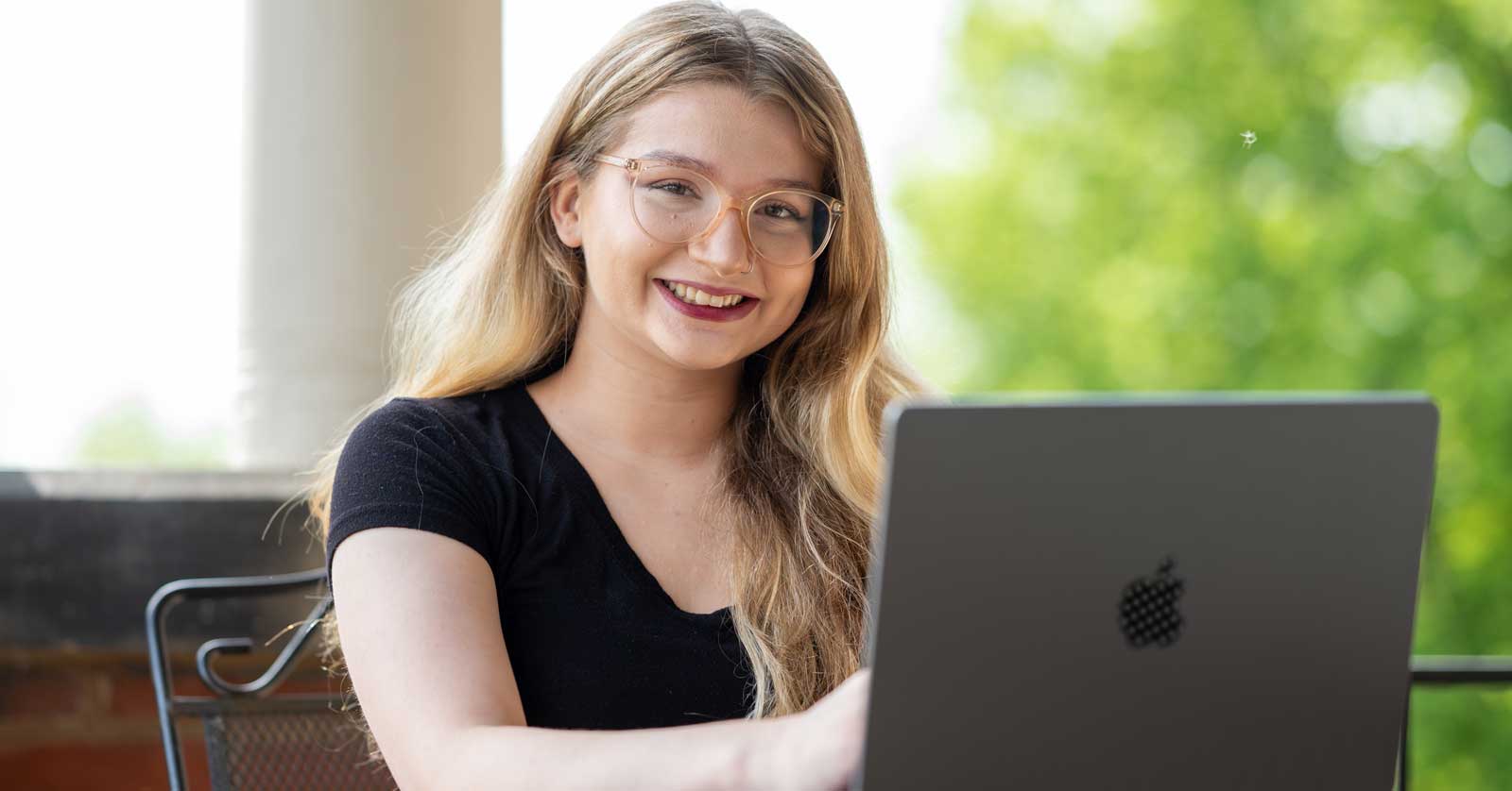 Student Brooke Martin with Laptop on Porch