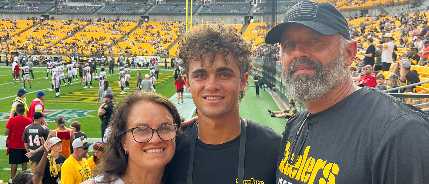 Student with his parents at football game.