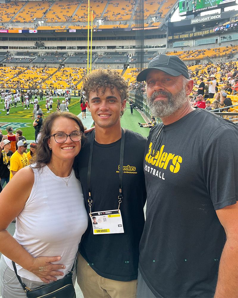 Student with his parents at a football game.